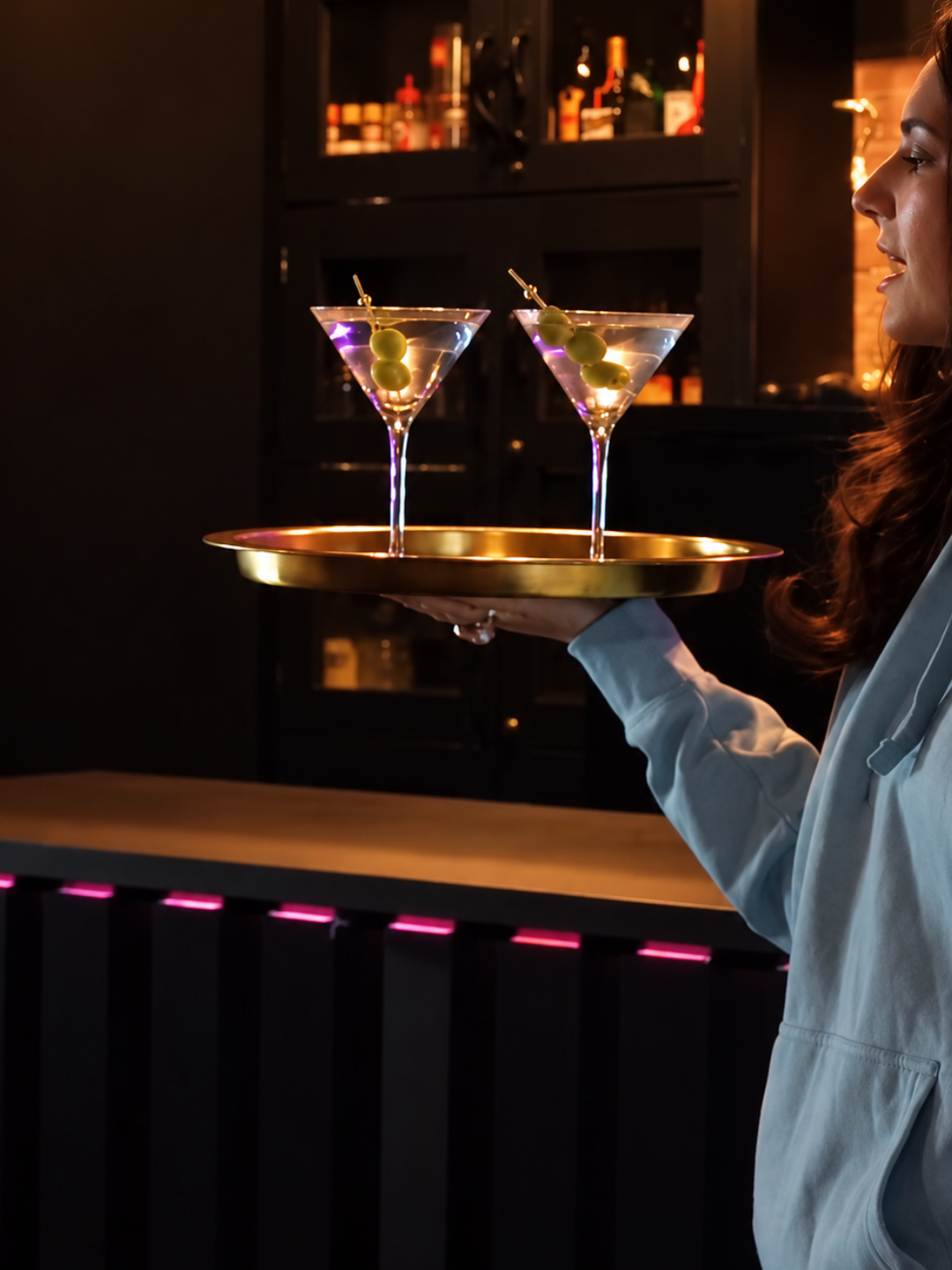 Two olive martinis carried on a gold tray